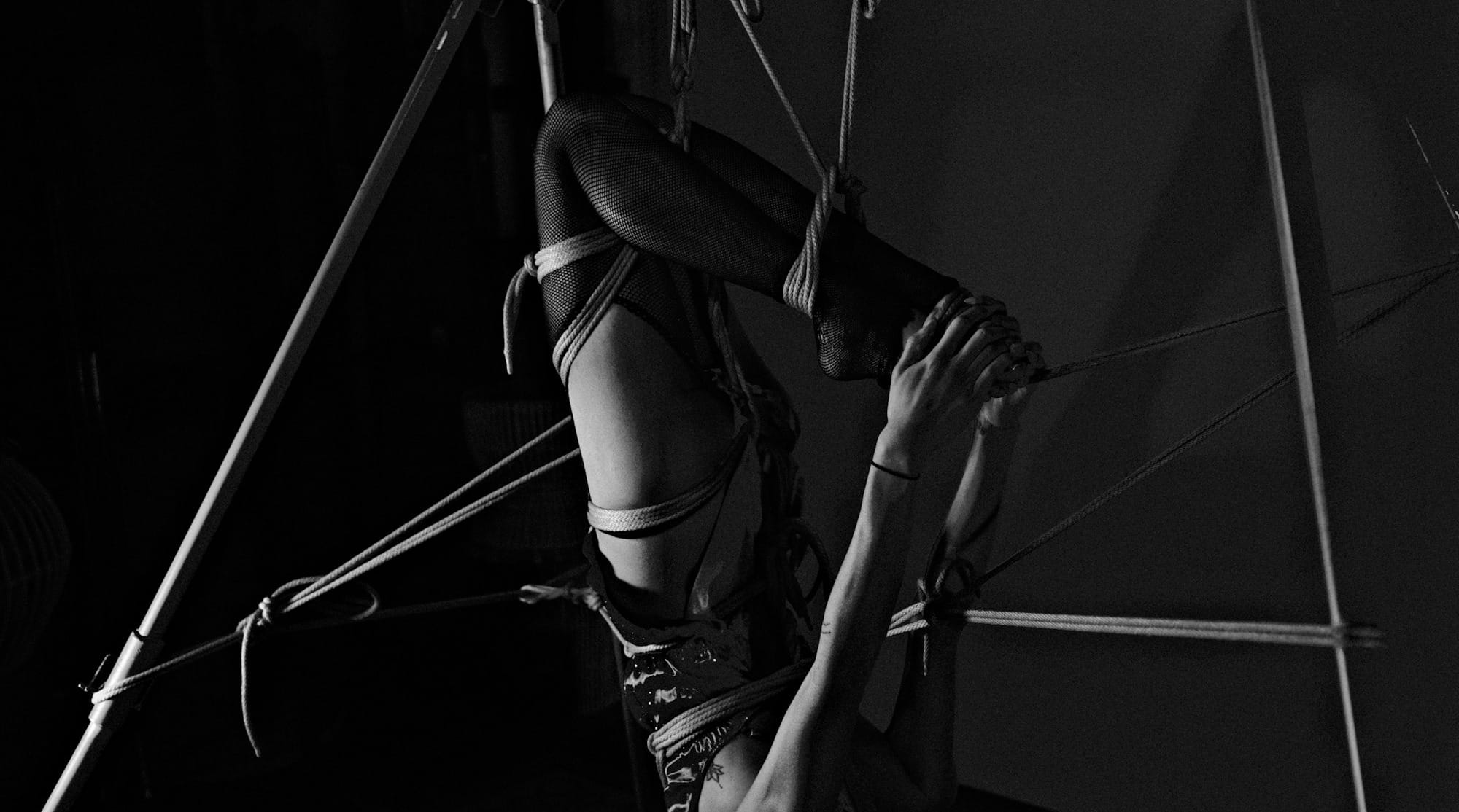 A woman hanging upside down on a pole