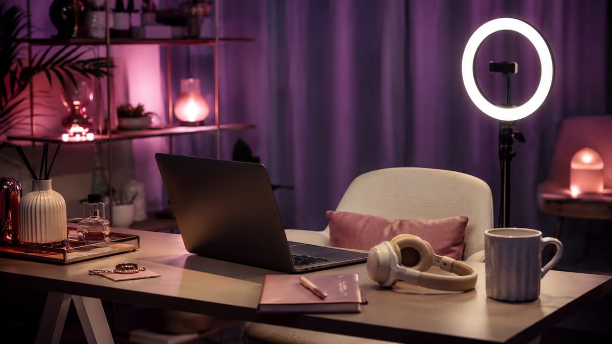 Postazione creator con laptop e ring light, simbolo del sex work digitale e delle piattaforme erotiche online.