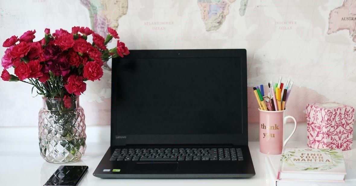 Scrivania ordinata con laptop e taccuino, concetto di lavoro sicuro e presenza digitale