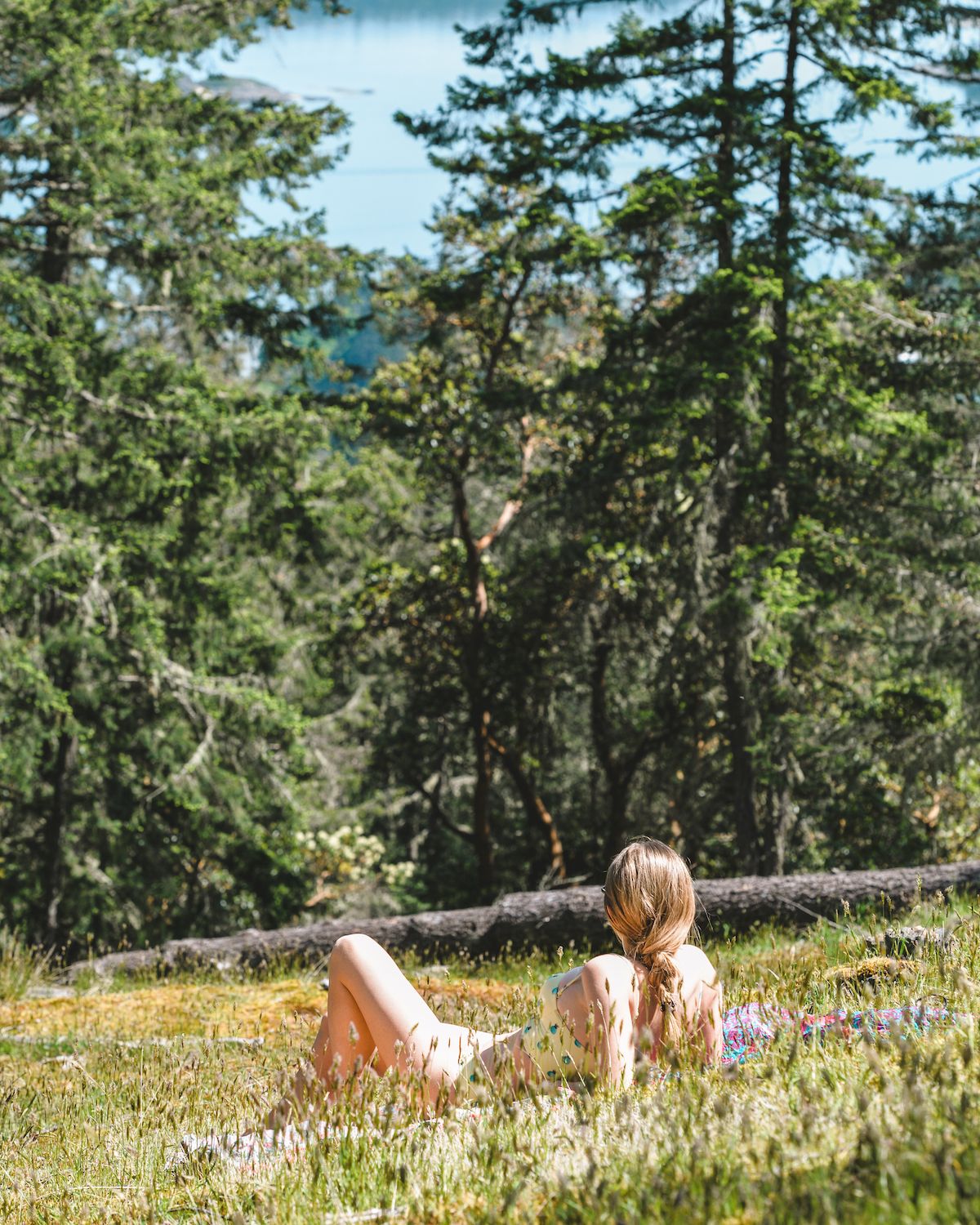 Cec laying in the grass on a blanket enjoying nature at home on Salt Spring Island