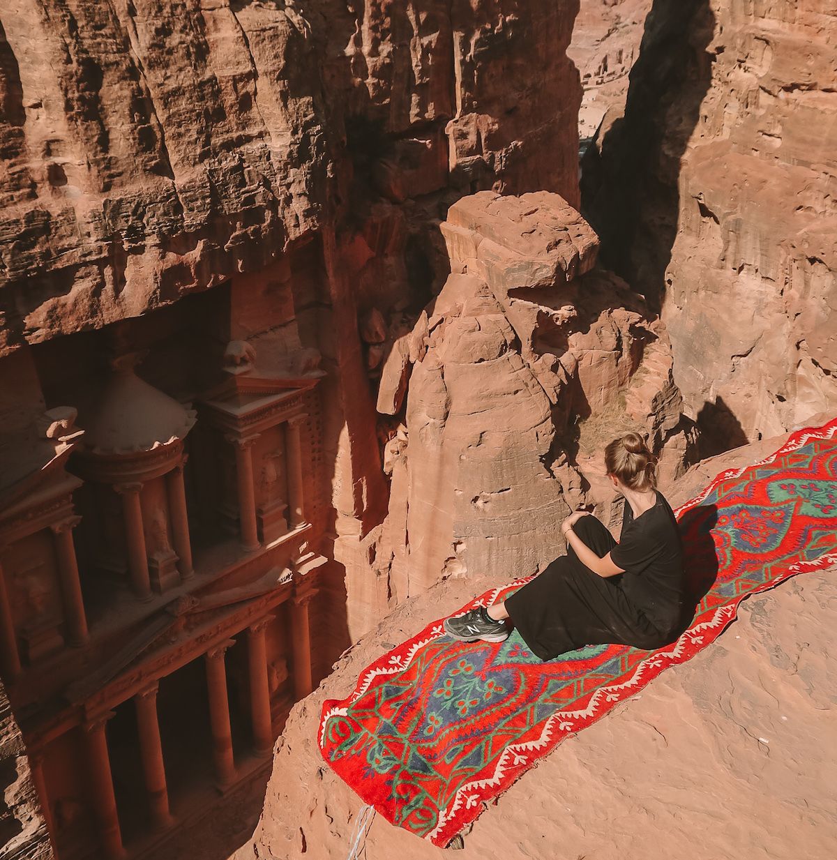 Cec perched on a cliff overlooking the Treasury in Petra