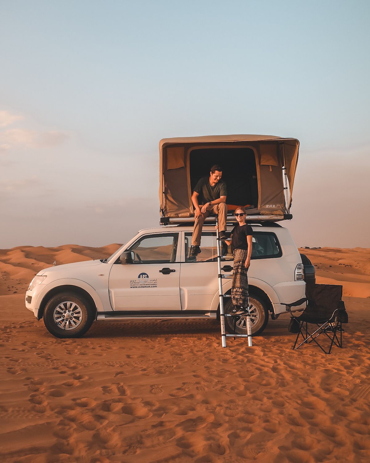 Cec and Ari camping in the Oman desert with a rooftop tent