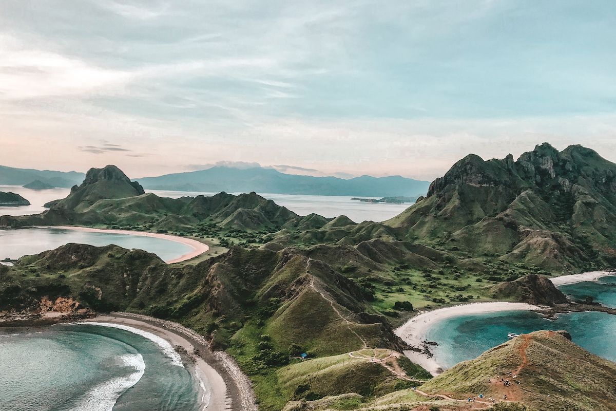 Padar Island viewpoint in Komodo National Park, Indonesia, reveals dramatic green ridges and turquoise bays below.
