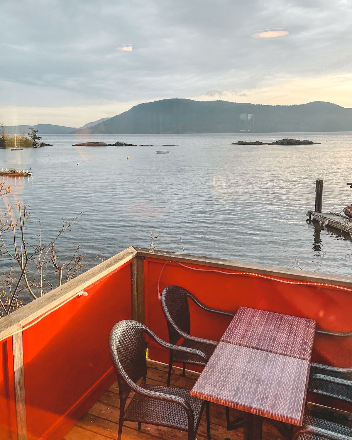 Outdoor dining deck at Seaside Restaurant with red walls and stunning ocean views.