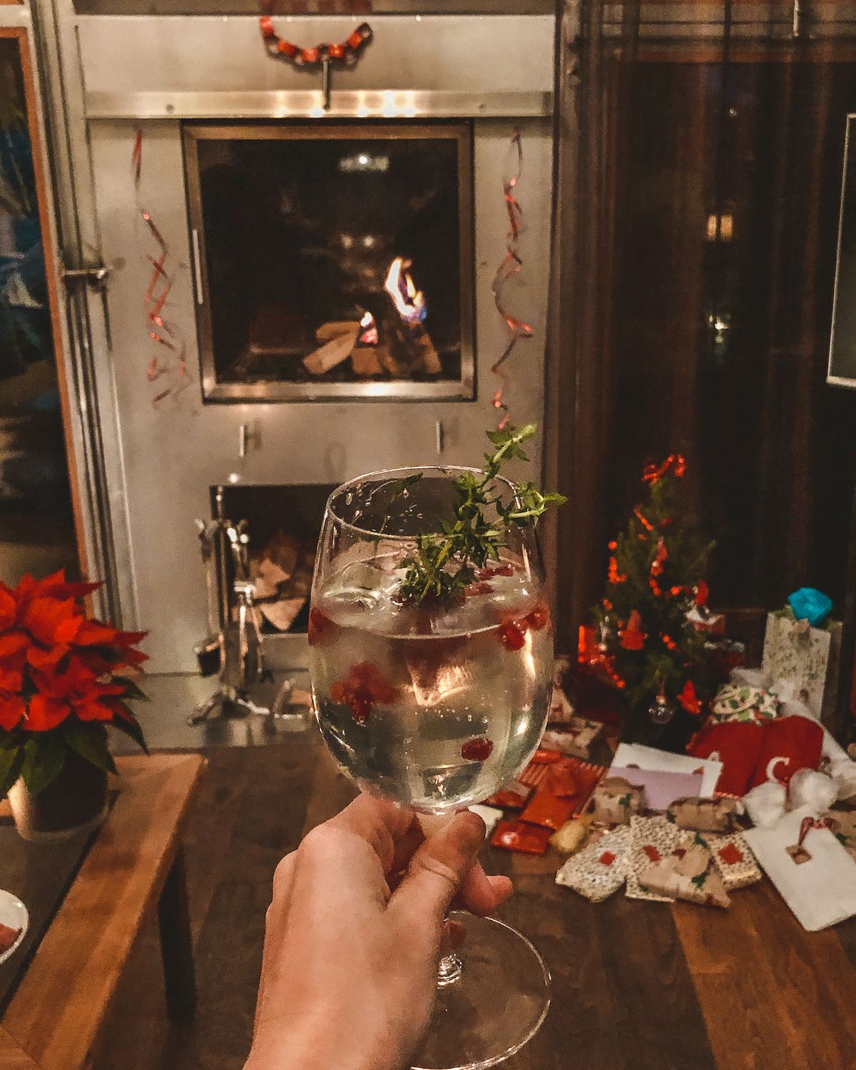 Christmas cocktail held in front of a fireplace