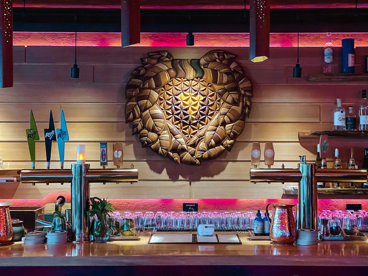 Mateada's bar interior with wooden wall art and ambient pink and orange lighting.