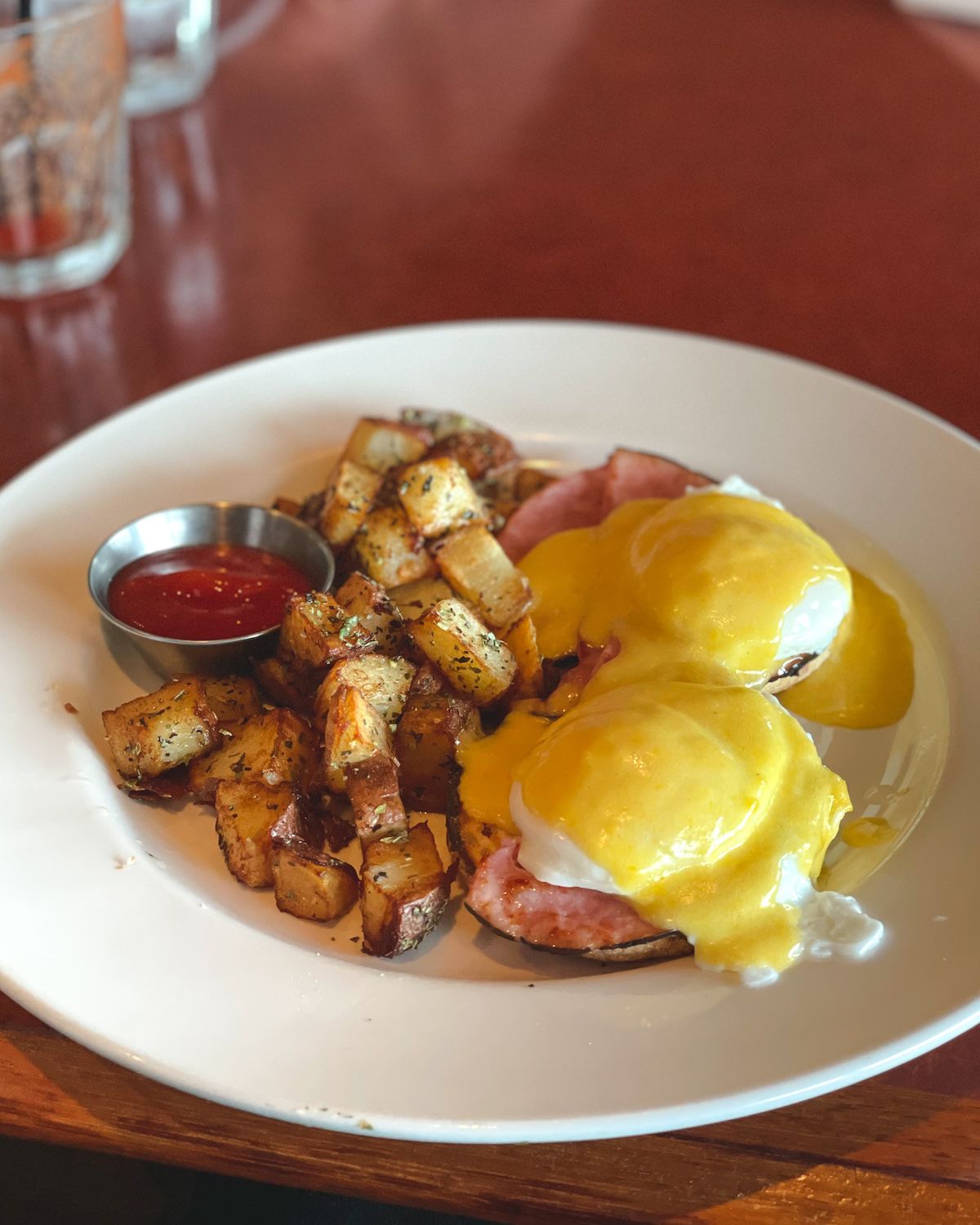 Eggs Benedict with crispy potatoes and ketchup, served at Salt Spring Inn.