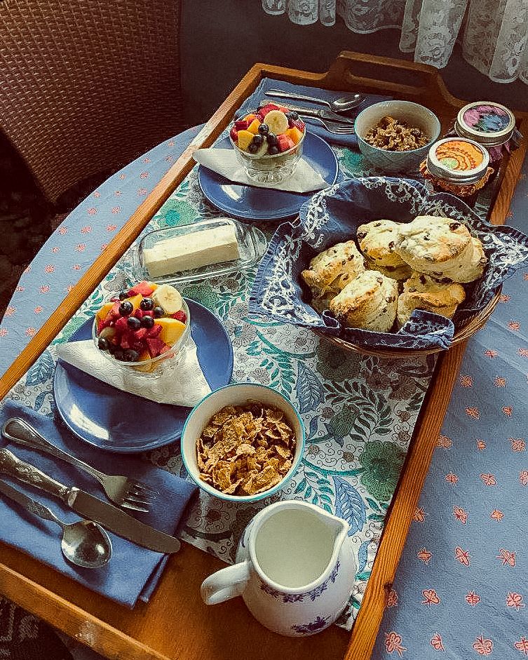 Scones, fresh fruit, and granola on a breakfast table with an island-style decor at a B&B on Galiano Island