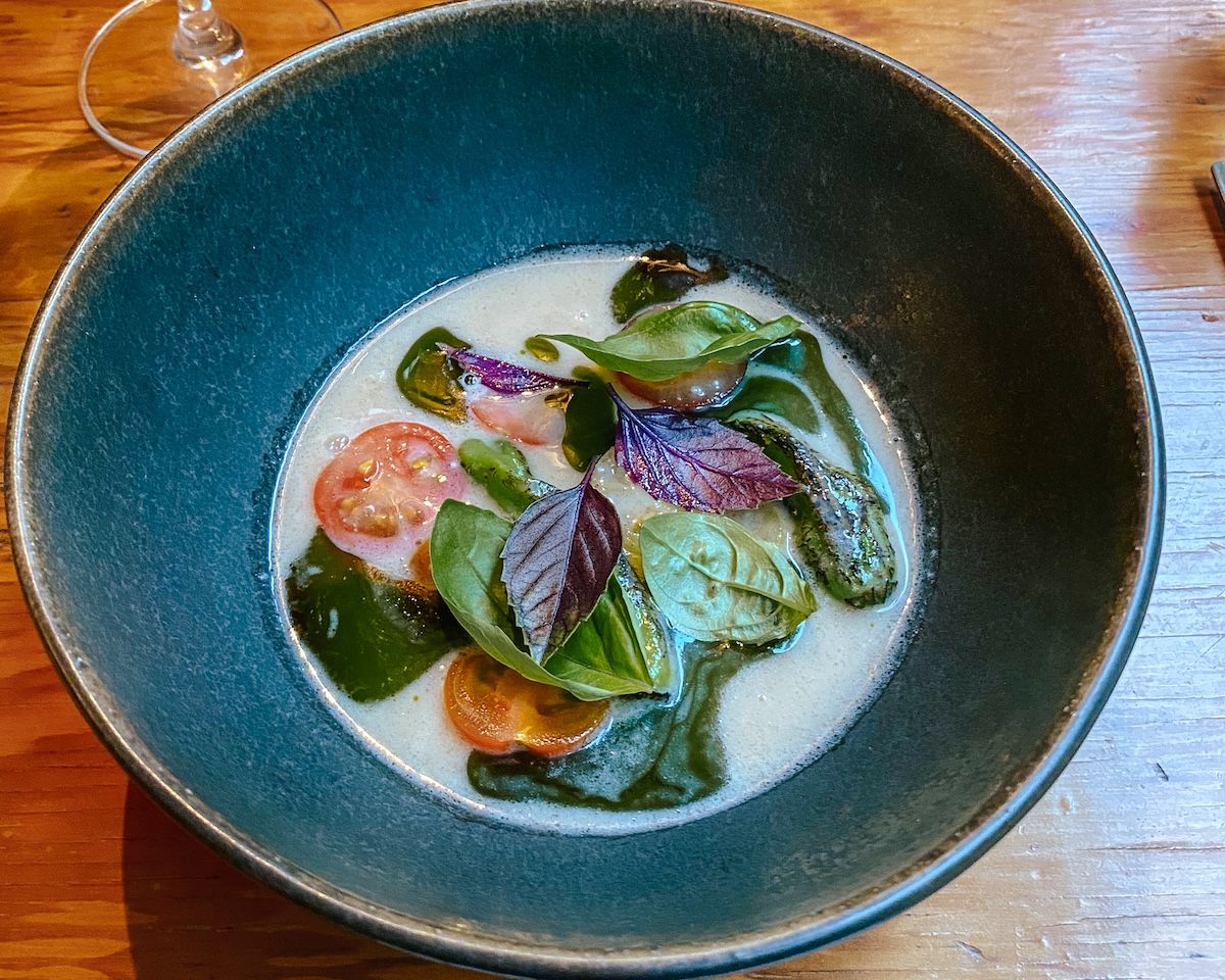 Dish of koji and fish bone broth with tomato and fir oil served a Pilgrimme Restaurant