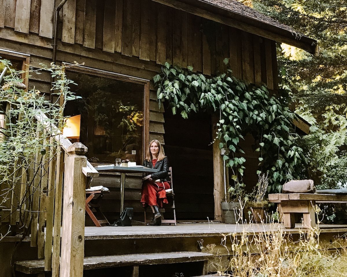 Cec dining on a rustic deck surrounded by forest at the secluded Pilgrimme restaurant.