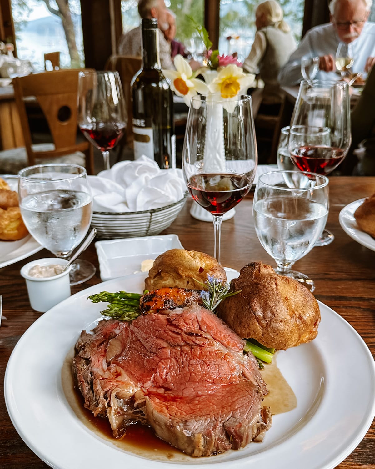 Prime rib dinner with popovers and asparagus at Hastings House dining room, paired with red wine.