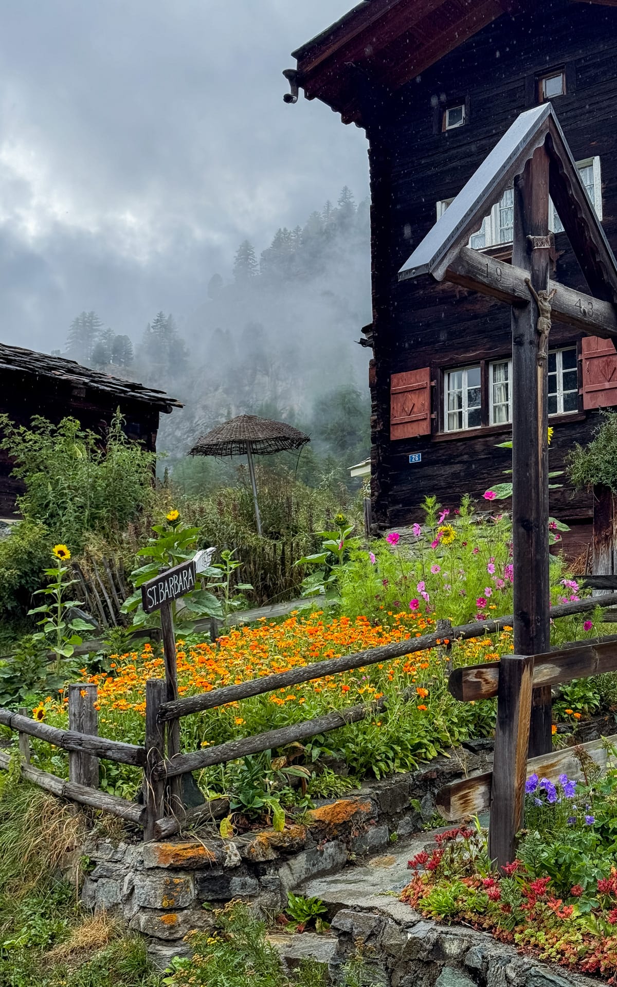 Garden of vibrant flowers outside a wooden chalet in Zum See village. 
