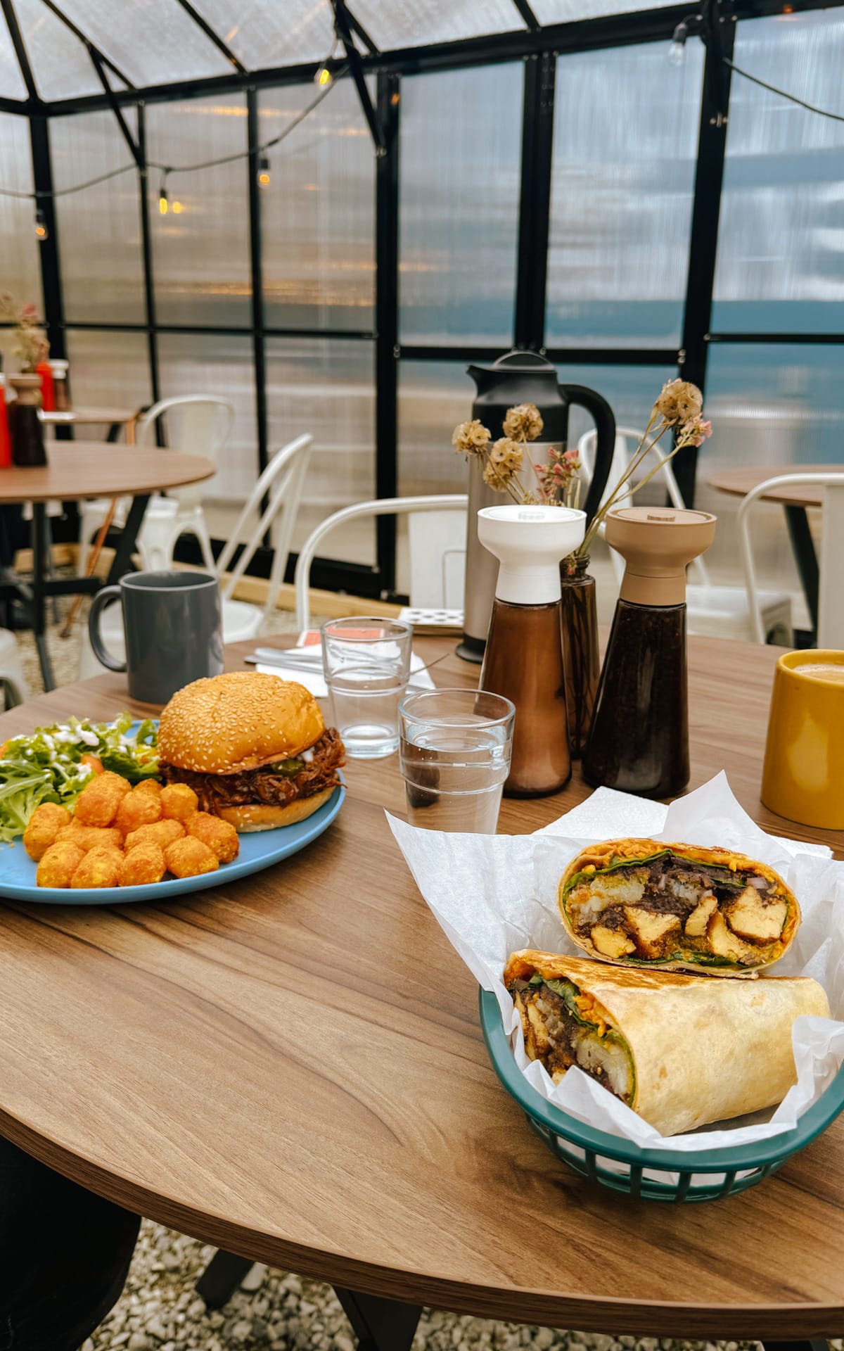BBQ Shrooms Burger with tater tots and side salad, next to a veggie burrito, served Ox Eats Grass on Salt Spring.