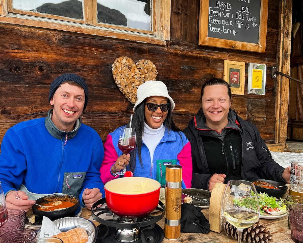 Group of friends enjoying a hearty cheese fondue meal on Chez Vrony's wooden terrace.