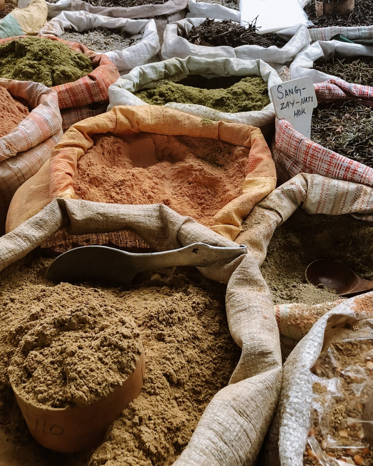 Bags of colourful spices and herbs at a Bhutanese market, neatly arranged.