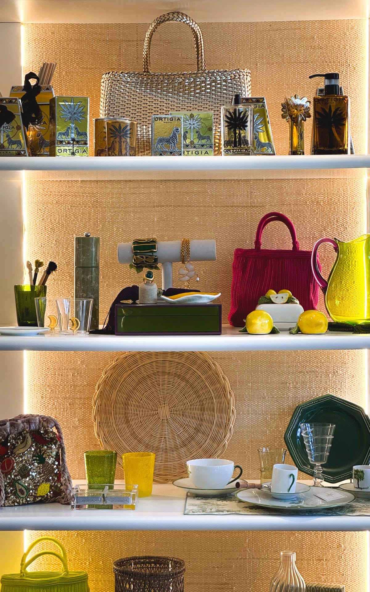 A boutique shelf at Voyage Holiday Shop displays woven bags, jewelry, and decorative home items in earthy tones, accented by pops of colour.