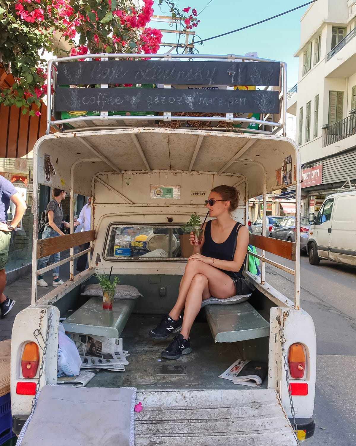 Cec sips a gazoz drink while sitting in the open back of a rustic truck in the Florentin neighbourhood of Tel Aviv.