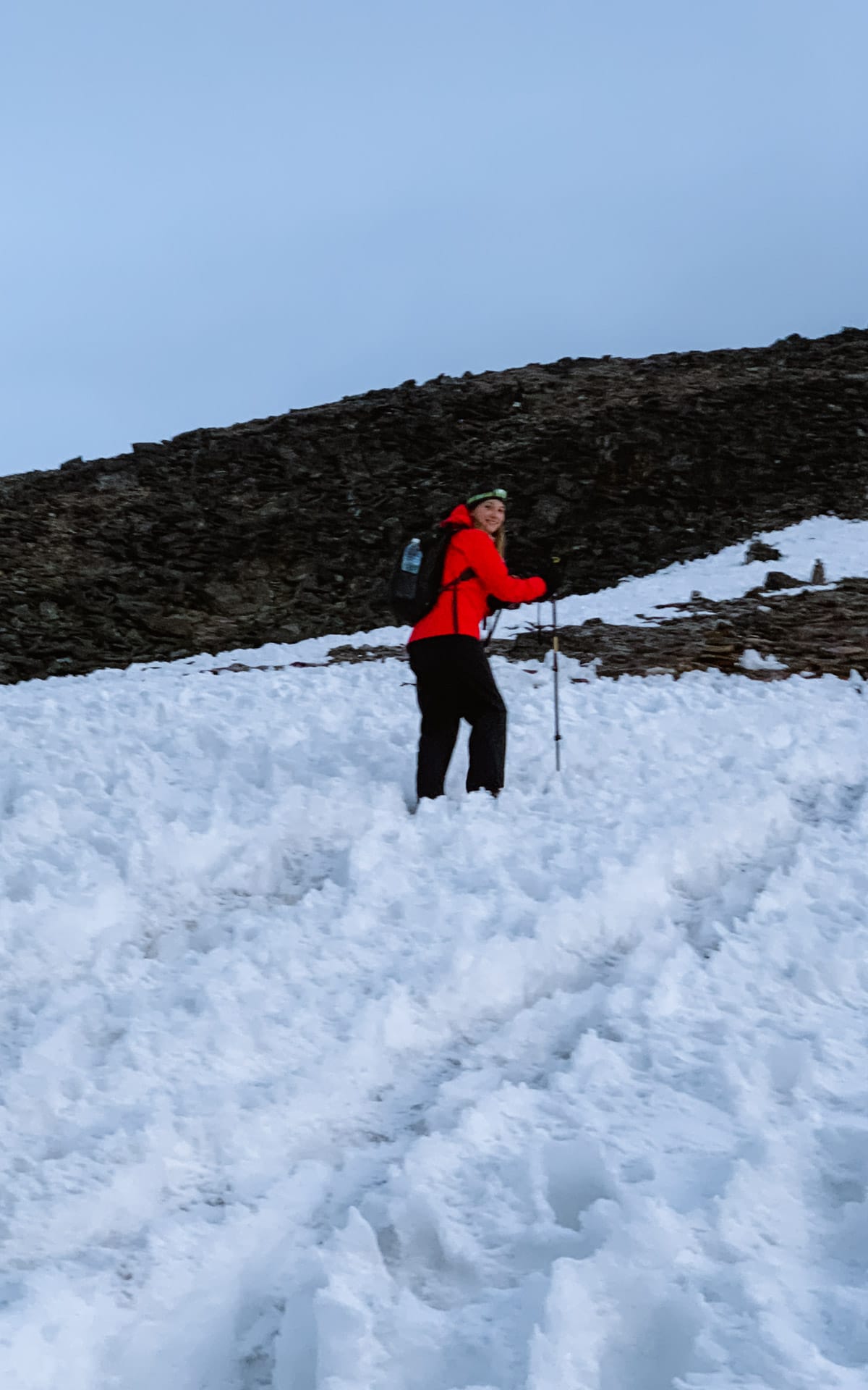 Cec hiking through snow on a steep mountainside and nearing the top of Gokyo Ri.