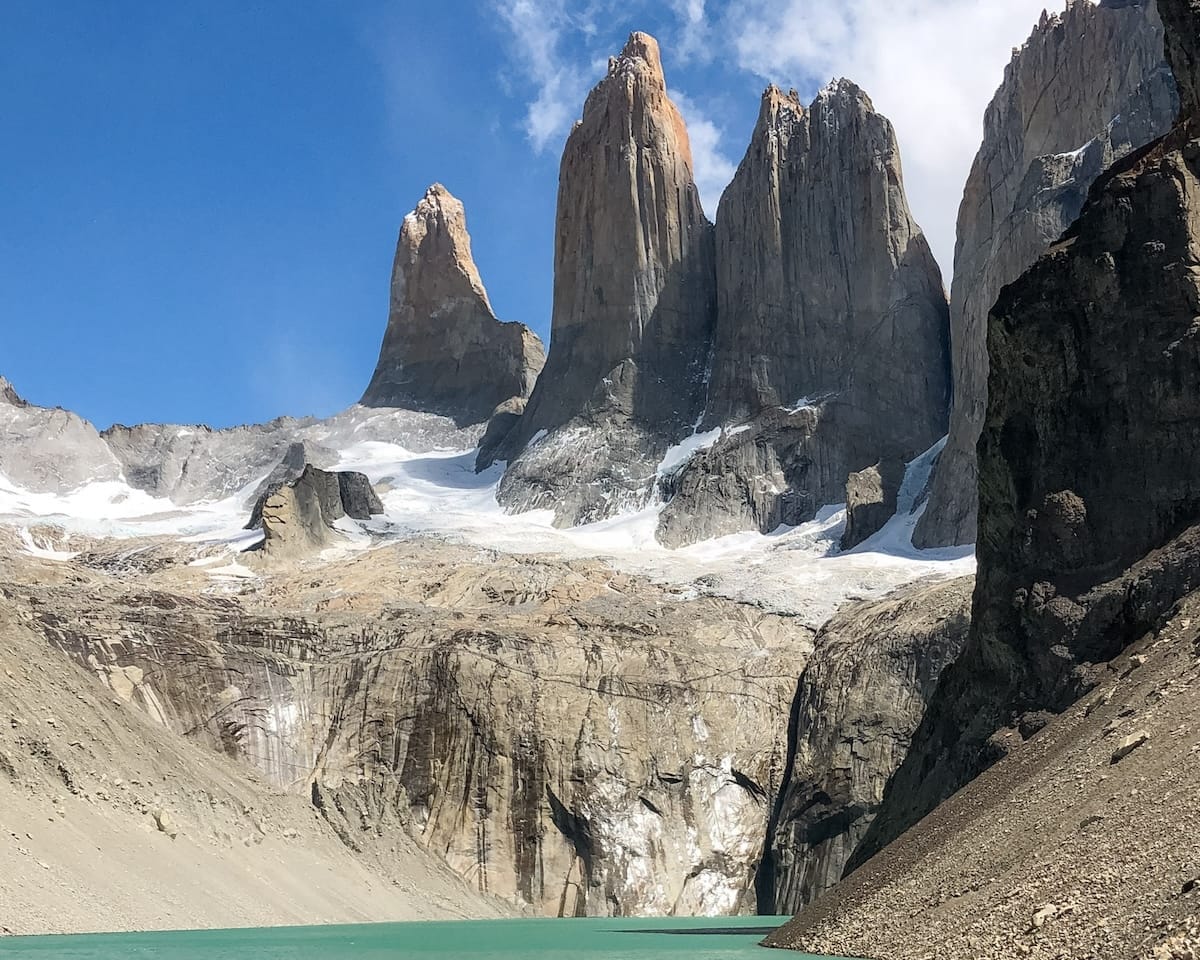 Sharp granite towers loom above a turquoise glacial lake in Patagonia’s Torres del Paine National Park, Chile.
