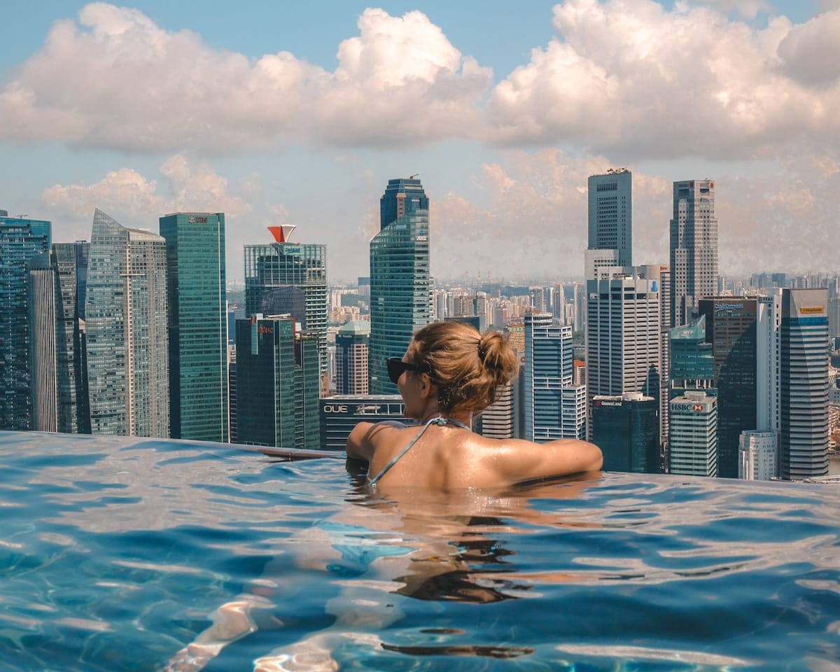 Cec relaxing in the infinity rooftop pool at Marina Bay Sands, gazing at the Singapore skyline.