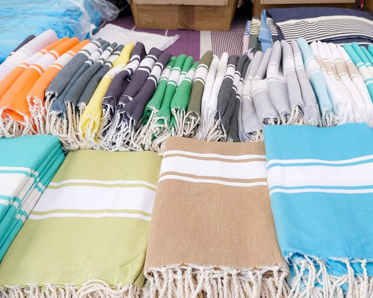 Colourful striped beach blankets neatly folded and displayed at a market in Cap Ferret.