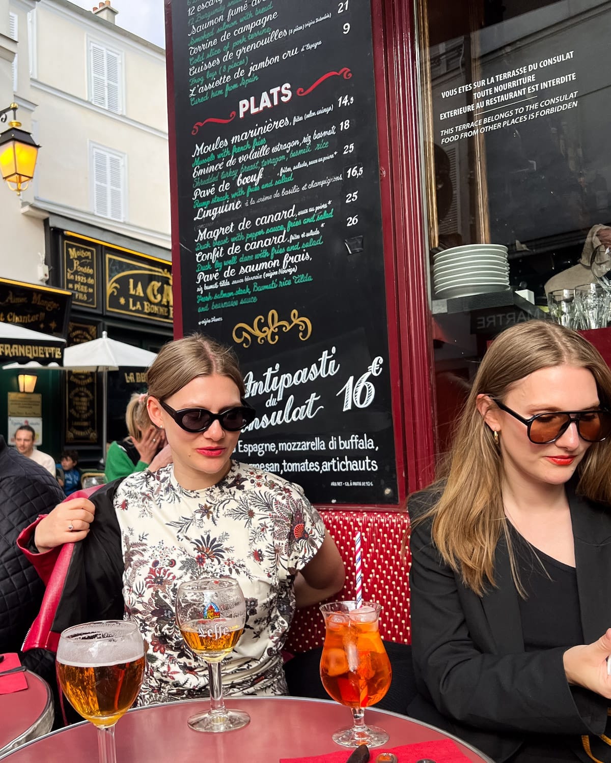 Cec and her sister at a sidewalk cafe with drinks in Montmartre, Paris.