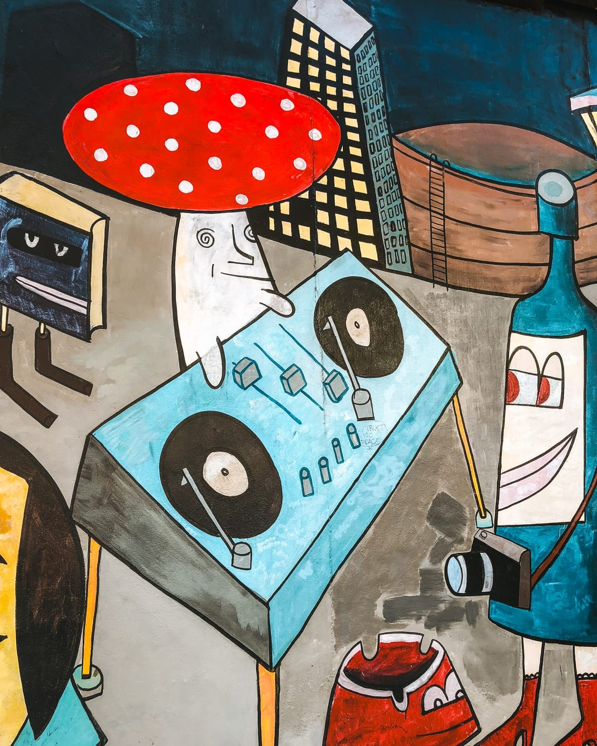 Funky street art in Berlin shows a DJ mushroom character and playful urban illustrations.