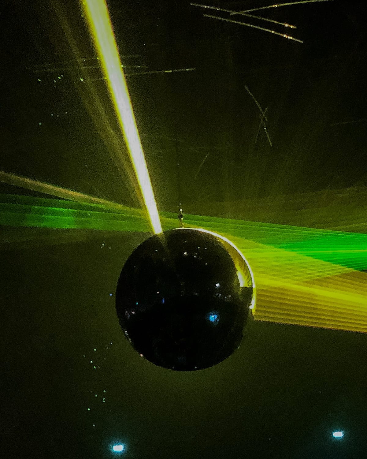 Laser lights reflect off a spinning disco ball in a dark nightclub in Amsterdam.