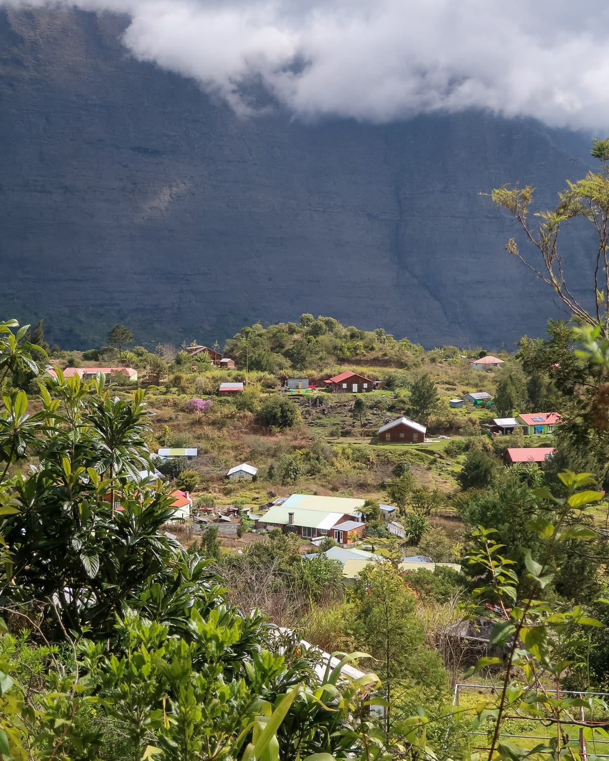 Small Creole village with colourful rooftops sit nestled in a green valley inside a caldera.