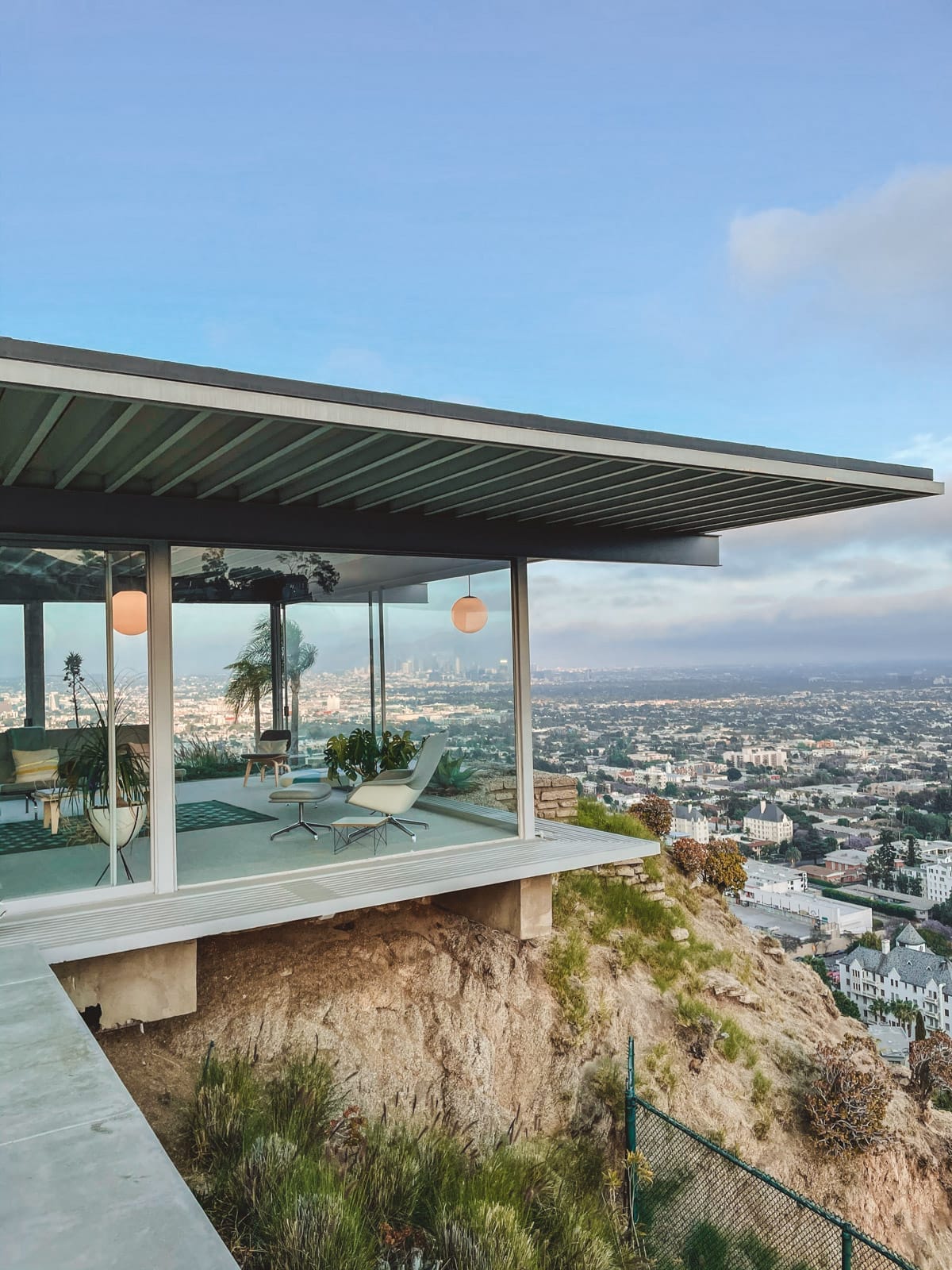 Mid-century Stahl House in Los Angeles with glass window walls perched on a cliffside with sweeping views of the city skyline.