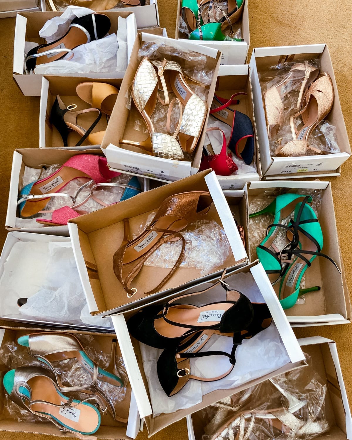 An assortment of glamorous tango shoes in open boxes at Comme Il Faut - glittery, metallic, and bold, ready for a night of dancing.