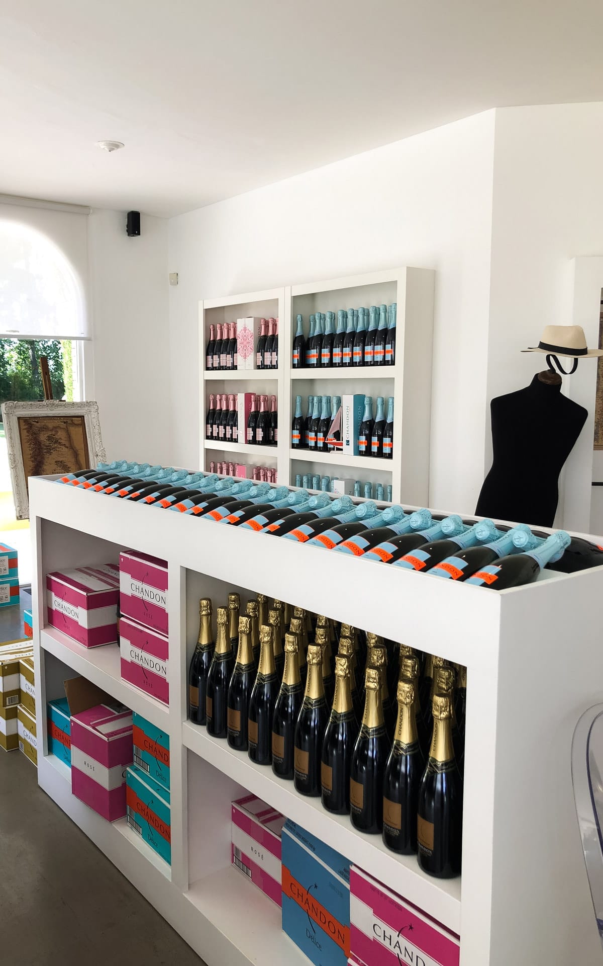Bright wine shop at Chandon Winery with shelves lined with pink and blue sparkling wine bottles and colourful boxes