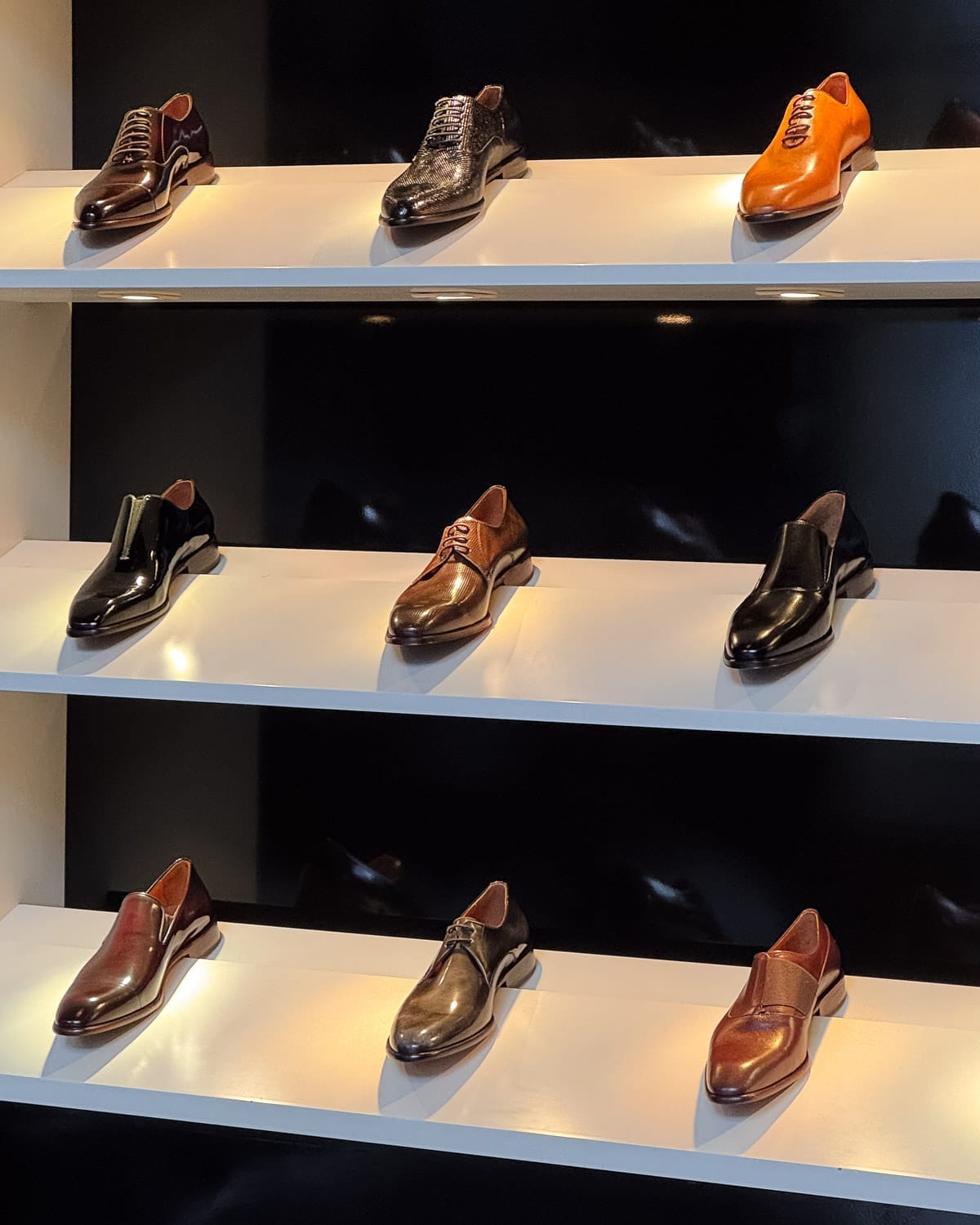 Display of polished leather mens shoes at Teran on backlit shelves, one of the best places to shop in Palermo.