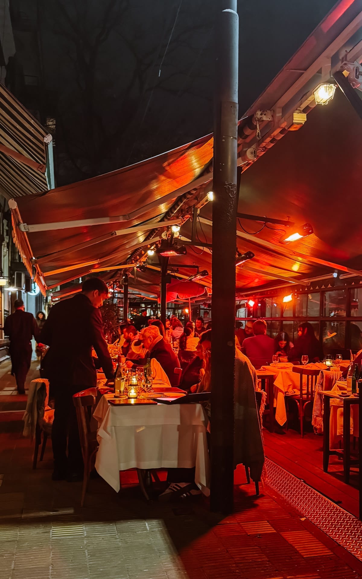 Outdoor dining at Don Julio under glowing red lights, one of the best things to do at night in Buenos Aires.