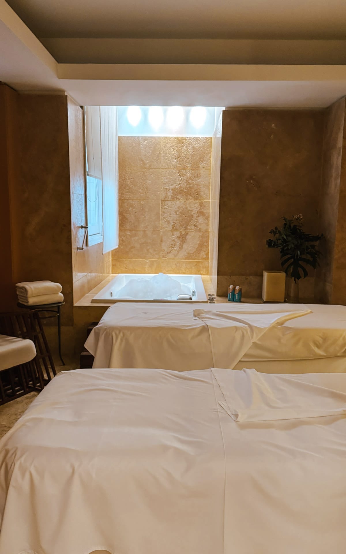 Spa suite with two massage tables and a bubbling jacuzzi tub at Ahim Wellness & Spa in Palacio Duhau.