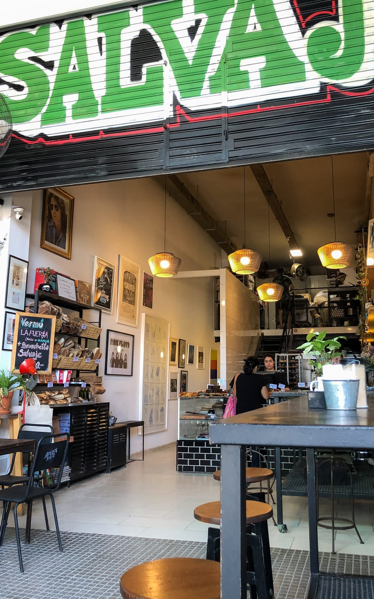 Eclectic Salvaje Bakery with black tile, warm lighting, and local art in an industrial space.