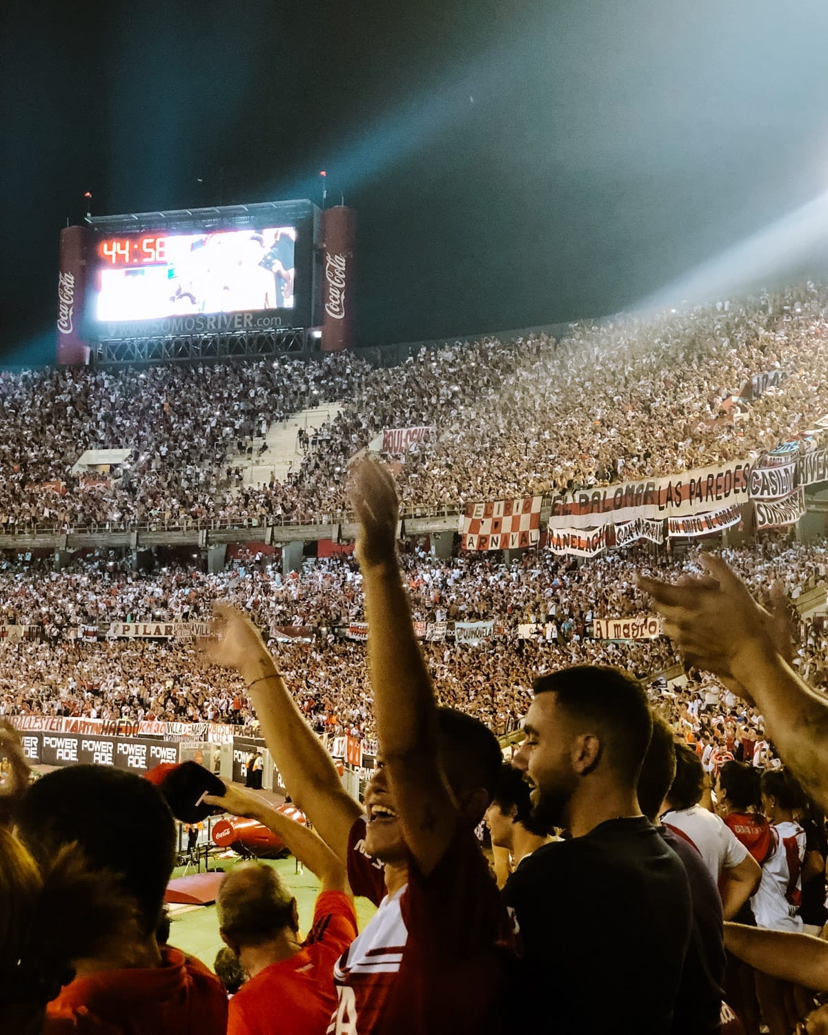 Fans cheer passionately during a River Plate vs. Racing Club match, an exciting thing to do in Buenos Aires at night.