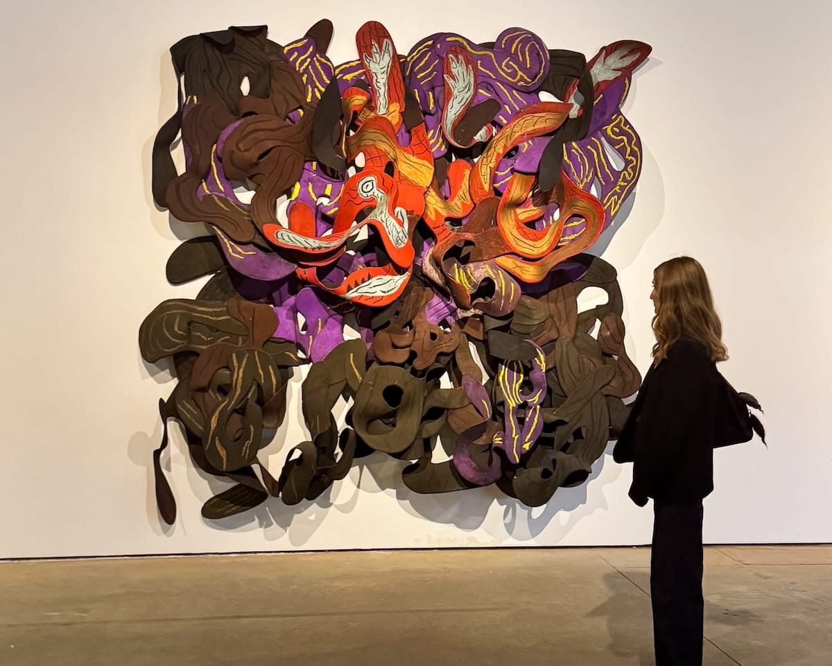Cec standing in front of a large, colourful contemporary art installation in Casa Bradesco.
