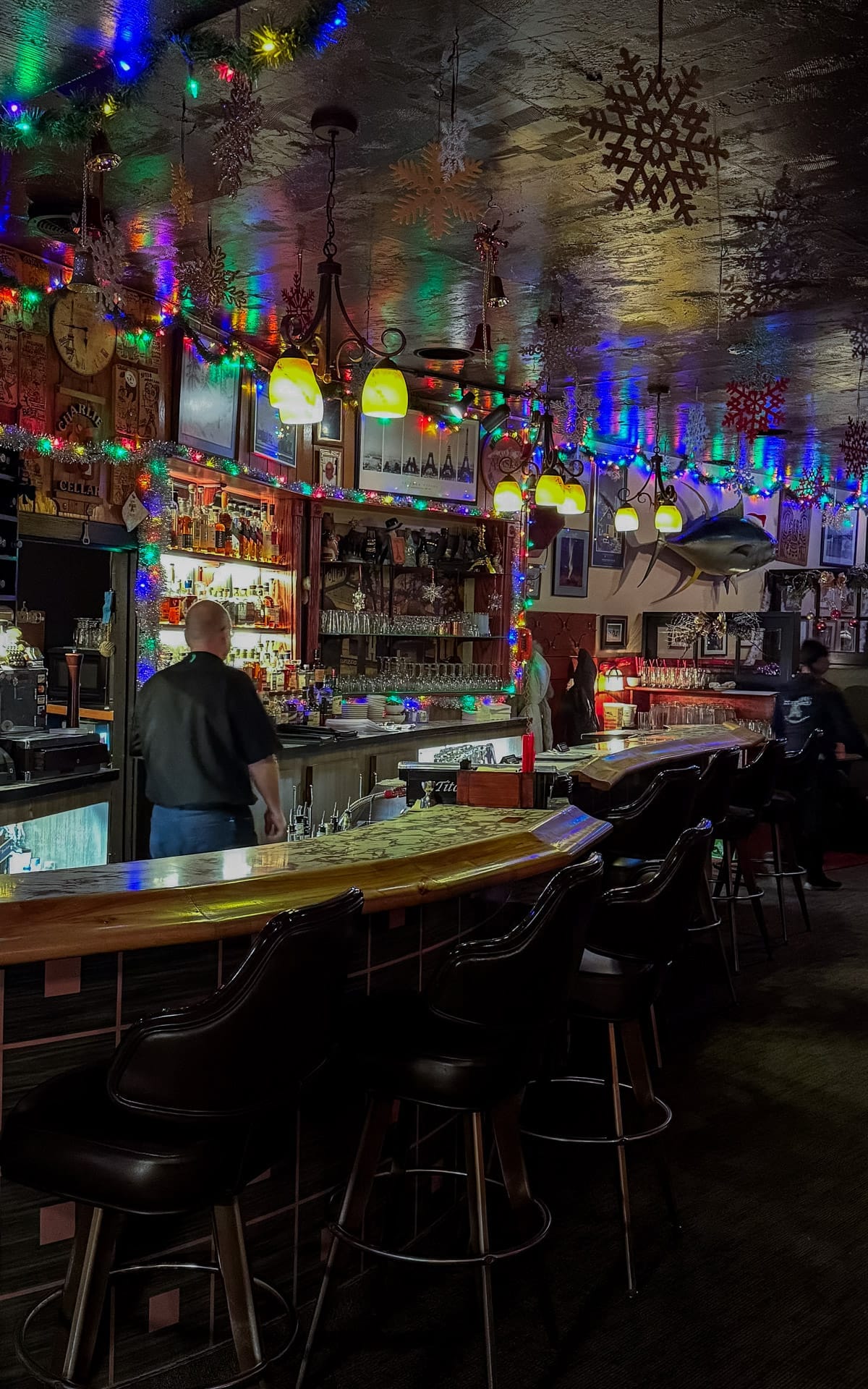 Classic bar interior of Club Paris decorated with Christmas lights and vintage memorabilia.