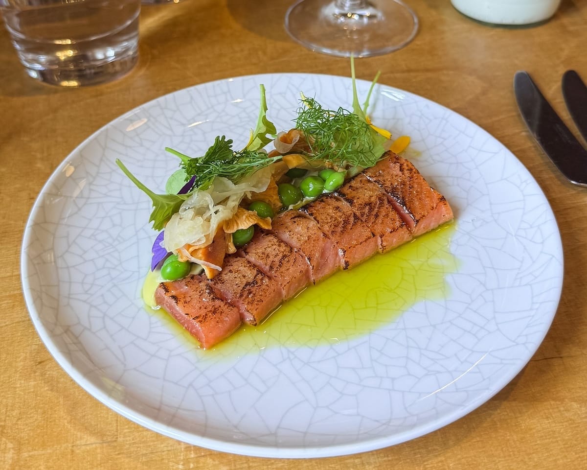 Modern Finnish salmon dish served with herbs and seasonal vegetables at Lonna's Restaurant.