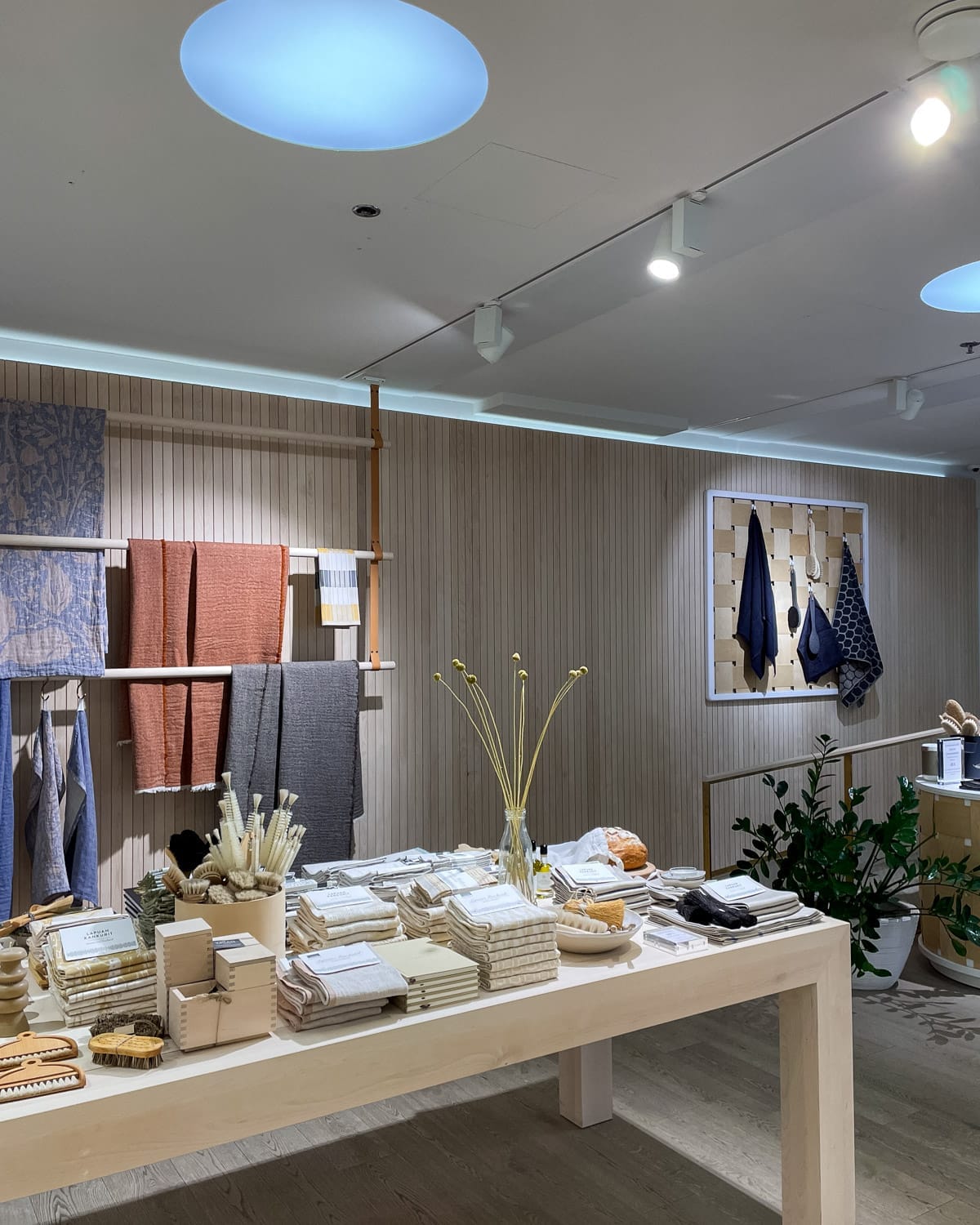 Minimal Lapuan Kankurit boutique shop displaying linen textiles, wooden brushes, and home goods.