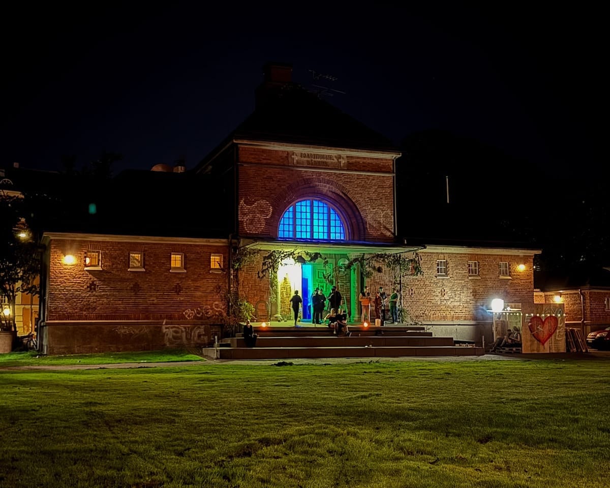 Former brick morgue building in Helsinki lit up at night during Jungle Unit's techno event.