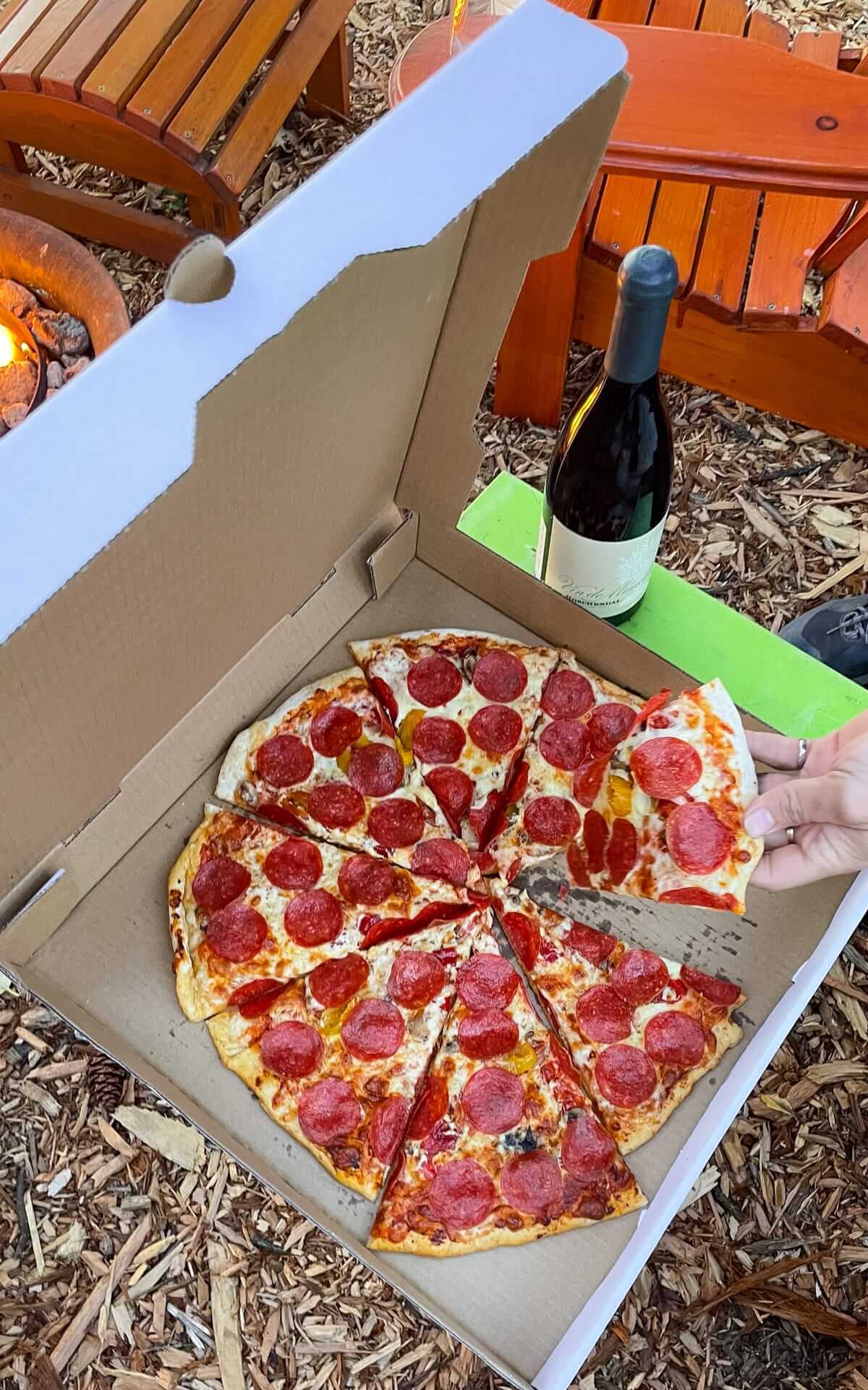Pizza from Hornby Island Bakery Pizzeria with some wine at our glamping spot outdoors.