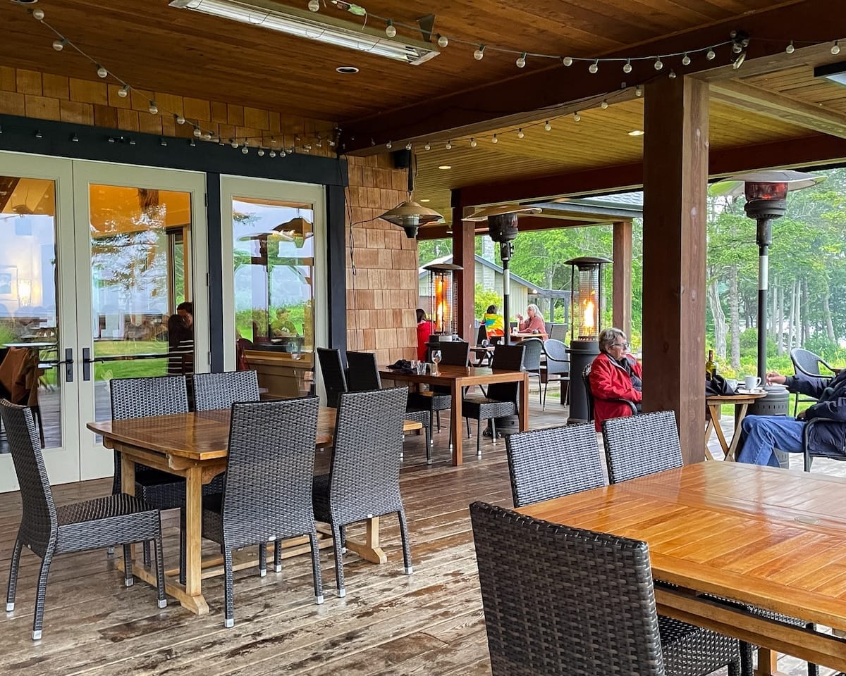 Covered patio dining at The Breeze Restaurant overlooking the grounds at Sea Breeze Lodge.