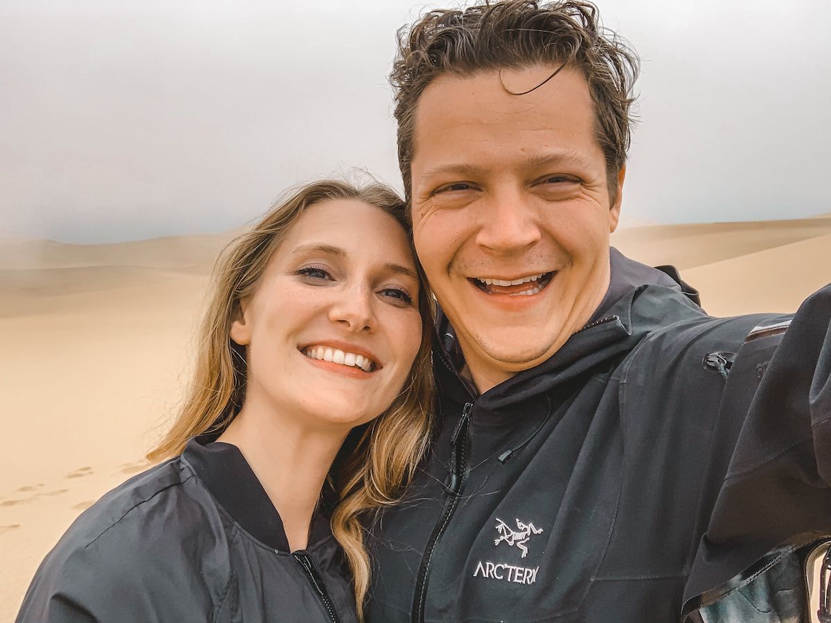 Cec and Ari with big smiles looking into the camera during their travels