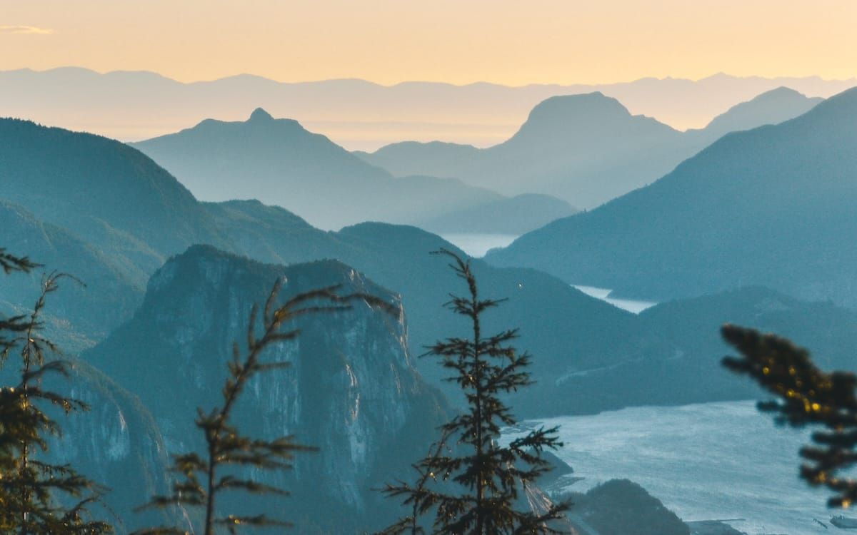 A scenic view of misty blue mountain ridges fading into the horizon in West Coast BC, one of North America's best travel destinations.