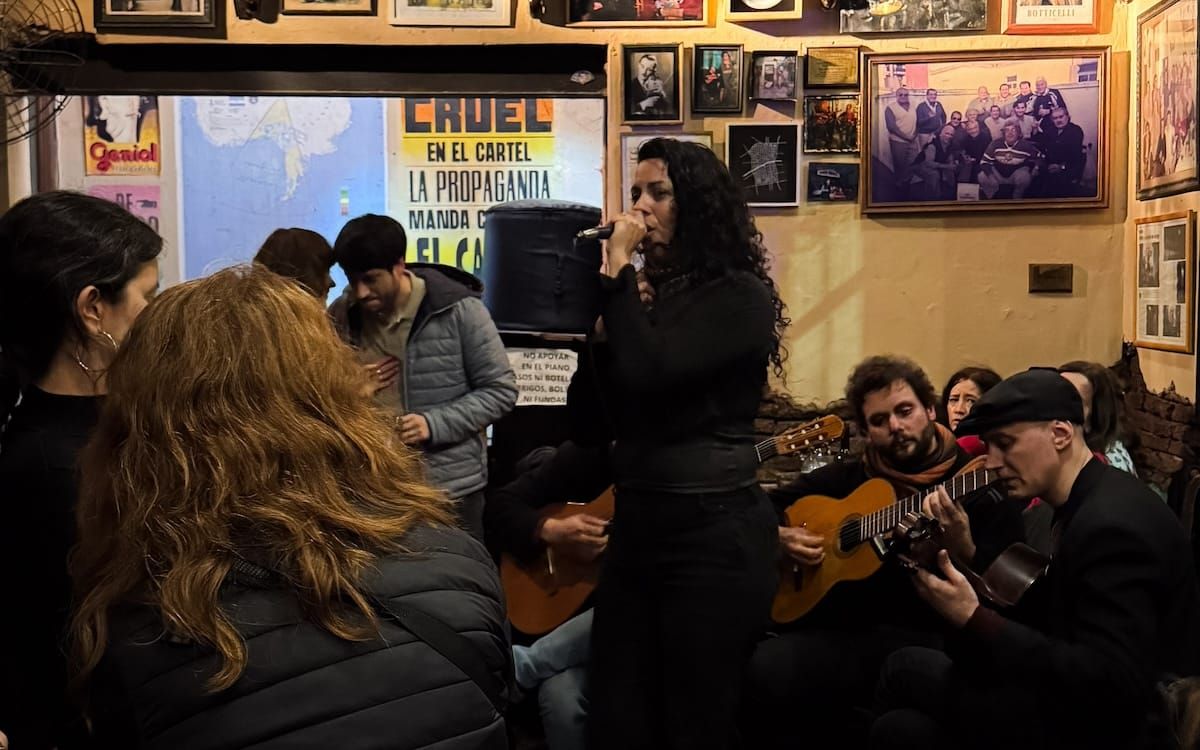 A woman sings folk songs with guitarists accompanying her at El Boliche de Roberto, one of Buenos Aires' best nightlife spots.