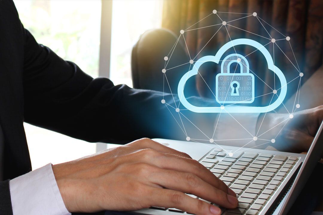 Businessman accessing the cloud on his laptop with an icon of a cloud and a lock. 
