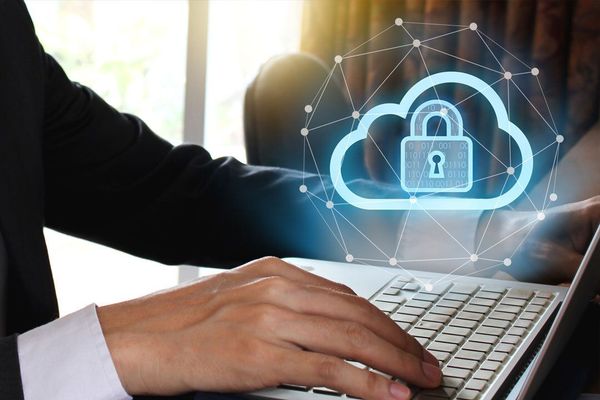 Businessman accessing the cloud on his laptop with an icon of a cloud and a lock. 