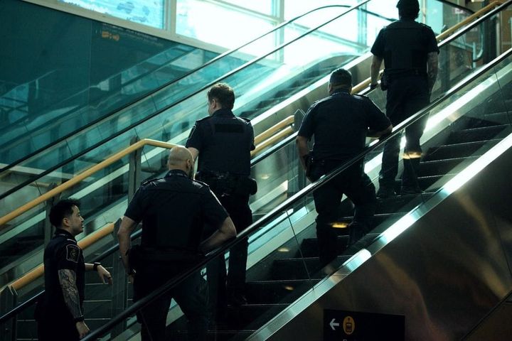 5 Canada Border Services Agency (CBSA) officers on an escalator
